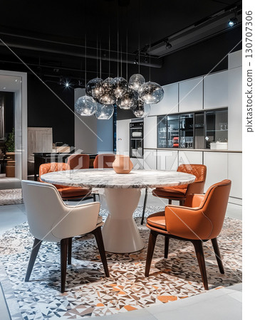 A sleek, modern dining room with a marble table, modern design chairs, and a unique design chandelier. The space is decorated in a sophisticated black and white color scheme. 130707306