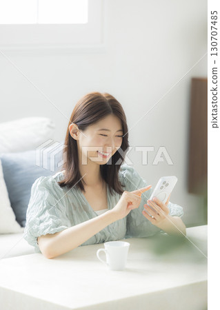 Woman looking at smartphone in the room Woman looking at smartphone in the room 130707485