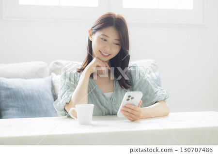 看智能手機的婦女在屋子裡 130707486