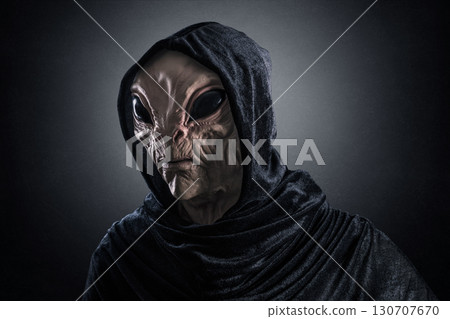 Mysterious humanoid alien at night over dark misty background Mysterious humanoid alien at night over dark misty background 130707670