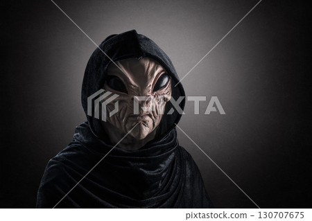 Mysterious humanoid alien at night over dark misty background  130707675