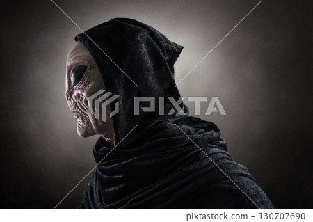 Mysterious humanoid alien at night over dark misty background  130707690