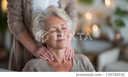 Relaxing massage for elderly woman with grey hair, eyes closed, enjoying the soothing touch, indoor setting, soft lighting, gentle care, blissful moment. 130708192