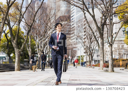 Businessman walking in the office town Businessman walking in the office town 130708423