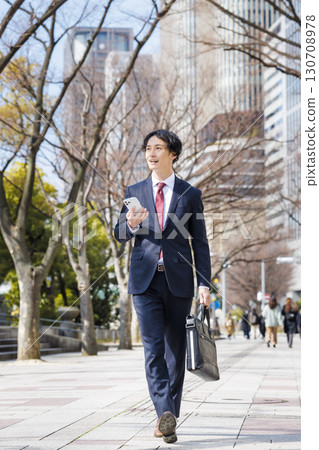 Businessman walking in the office town Businessman walking in the office town 130708978