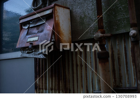 A rusty mailbox filled with mail, a rusty mailbox in an abandoned house 130708993