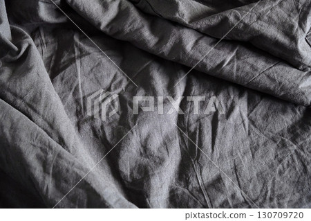 Textured crumpled gray fabric. Abstract background with natural wrinkle and fold. 130709720