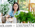 a portrait of beautiful happy asian woman traveler wearing a beautiful blue dress lifestyle enjoying in sitting coffee shop restaurant background 130709774