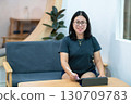 Portrait asian freelance people business female wearing glasses stylish hipster Draw or taking note on digital tablet with electronic pen for browsing internet, chatting and blogging in coffee shop. 130709783