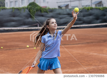 Girl practicing tennis on outdoor clay court with racket and tennis ball Girl practicing tennis on outdoor clay court with racket and tennis ball 130709866