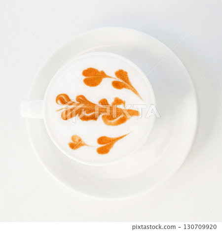 Cup of cappuccino with intricate latte art on a clean white saucer Cup of cappuccino with intricate latte art on a clean white saucer 130709920