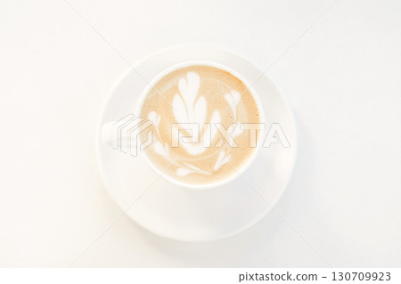 Latte coffee with artistic foam design served in a white cup and saucer Latte coffee with artistic foam design served in a white cup and saucer 130709923