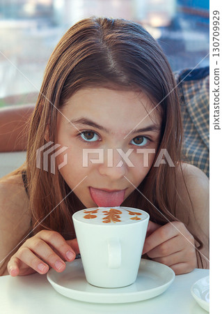Girl enjoying a cup of coffee with artistic latte art design 130709929