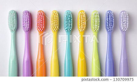 Dental Hygiene: Rows of colorful toothbrushes on a white surface. Cleaning, oral care, and health concept. Routine practices for healthy smile. 130709975