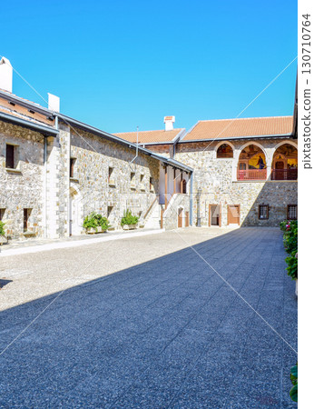 Historical stone monastery courtyard with arched frescoes in realistic style under bright clear sky. Historical stone monastery courtyard with arched frescoes in realistic style under bright clear sky. 130710764