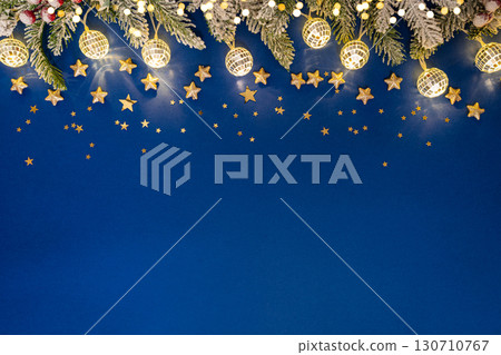 Christmas Lights and Stars with Snowy Pine on Blue Background 130710767
