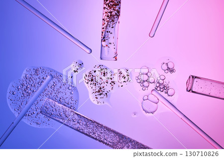 Textures of cosmetic serums in test tubes on a blue-purple background. 130710826