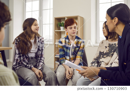 Elementary school students in casual wear sitting in circle in classroom Elementary school students in casual wear sitting in circle in classroom 130710903