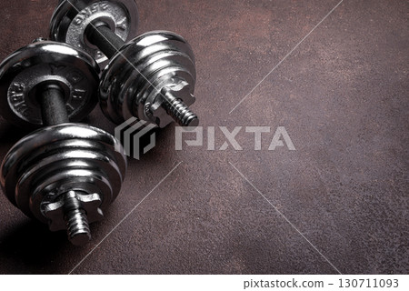 Heavy dumbbells on dark background 130711093