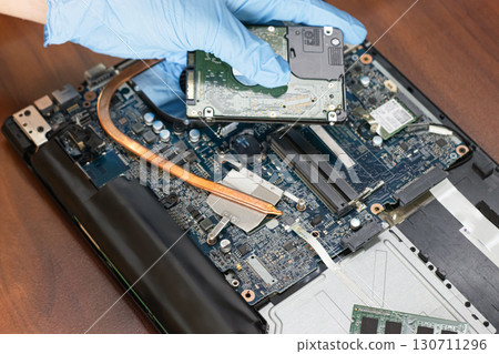 Technicians checking and repairing motherboards and computer hard drives Technicians checking and repairing motherboards and computer hard drives 130711296