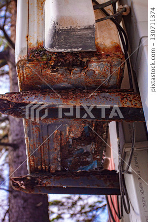 An old and rusty air conditioner hanging on the hotel building, in the sunny outdoor, seaside resort, 130711374