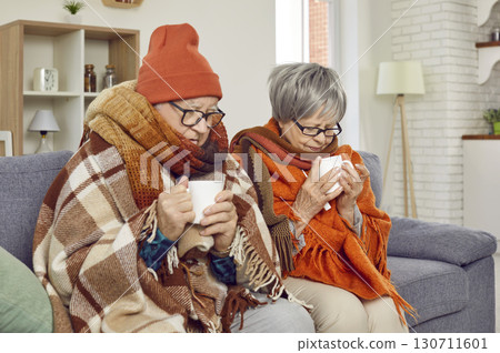 Senior Couple Warm with Tea on the Couch Senior Couple Warm with Tea on the Couch 130711601