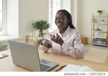 Friendly African American businesswoman using laptop to give consultation to client online. 130711614
