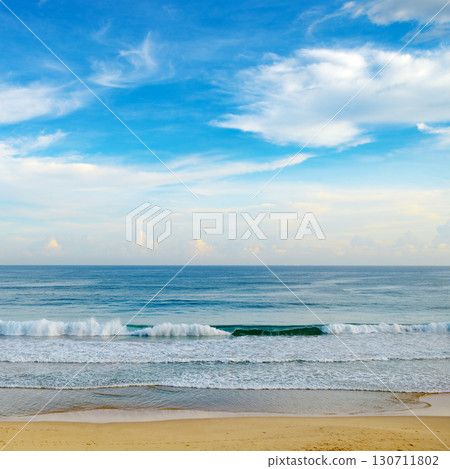 Bright morning landscape of blue sky with fluffy clouds and ocean coast. 130711802