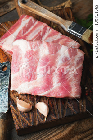 Raw pork ribs with spices, salt and rosemary on dark wooden background 130711965