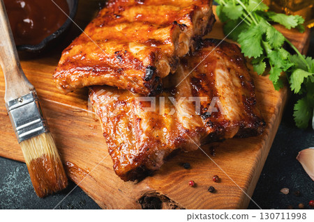 Spicy hot grilled spare ribs from a summer BBQ served with a hot chili pepper and fresh tomatoes 130711998