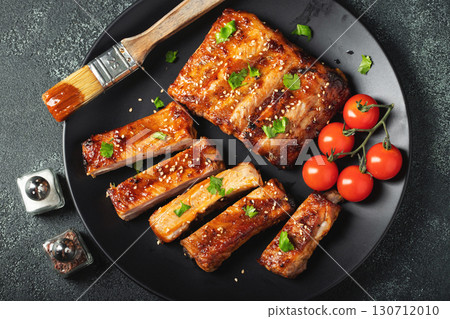 Hot grilled spare ribs from a summer BBQ served on a plate with sauce. Top view. Copy space Hot grilled spare ribs from a summer BBQ served on a plate with sauce. Top view. Copy space 130712010