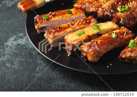 Hot grilled spare ribs from a summer BBQ served on a plate with sauce. Top view. Copy space Hot grilled spare ribs from a summer BBQ served on a plate with sauce. Top view. Copy space 130712014