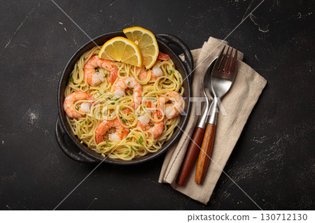 Delicious seafood pasta spaghetti with shrimps dish garnished with lemon and parsley top view on black background 130712130