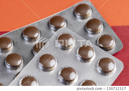 brown tablets in a plastic blister to ensure the safety of the medicine, several blisters with brown tablets 130712317