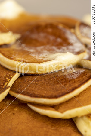 hot pancakes with butter that melts on the pancakes, a large pile of round pancakes with butter made from milk after cooking 130712338