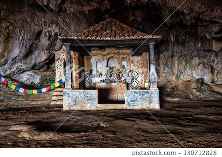 Dark interior of Lapa de Santa Margarida in Arrabida, Setubal, Portugal. Cave with small chapel of spontaneous worship Dark interior of Lapa de Santa Margarida in Arrabida, Setubal, Portugal. Cave with small chapel of spontaneous worship 130712828