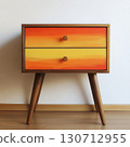 A vibrant table features a striking orange and yellow gradient on its drawers. It stands on slender wooden legs, enhancing its modern aesthetic. This piece brightens any room. 130712955