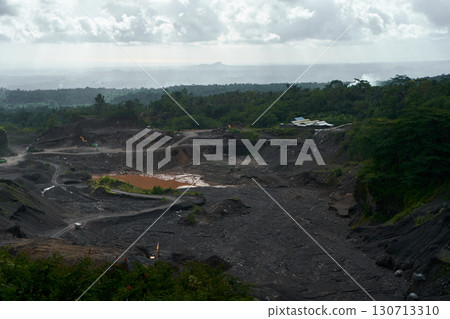 A stone quarry in Indonesia. Large equipment such as bulldozers and dump trucks are working on the site. A stone quarry in Indonesia. Large equipment such as bulldozers and dump trucks are working on the site. 130713310