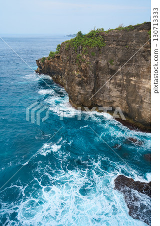 Cinematic aerial landscape shots of the beautiful island of Nusa Penida. Huge cliffs by the shoreline and hidden dream beaches with clear water and foaming wave. 130713333