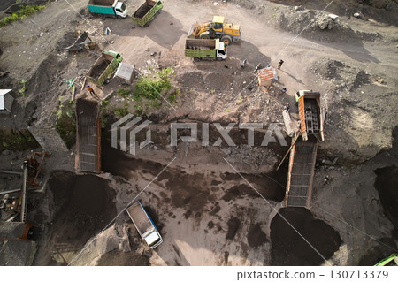 A stone quarry in Indonesia. Large equipment such as bulldozers and dump trucks are working on the site. A stone quarry in Indonesia. Large equipment such as bulldozers and dump trucks are working on the site. 130713379