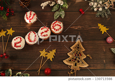 Winter background for greeting card. Curd muffins with glazed pomegranates with numbers 2026 in the form of a clock, an idea for decorating food and decorating New Year's dishes for children. Winter background for greeting card. Curd muffins with glazed pomegranates with numbers 2026 in the form of a clock, an idea for decorating food and decorating New Year's dishes for children. 130713566