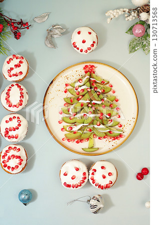 Christmas and New Year dishes. Curd muffins with pomegranates in glaze with numbers 2026 and a kiwi tree for a festive table, an idea for decorating food and decorating New Year dishes for children 130713568