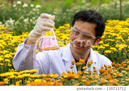 Scientist in protective gloves and safety glasses holding flask with purple liquid in flower field, symbolizing agricultural research, biotechnology, plant science, eco innovation, and sustainable Scientist in protective gloves and safety glasses holding flask with purple liquid in flower field, symbolizing agricultural research, biotechnology, plant science, eco innovation, and sustainable 130713712