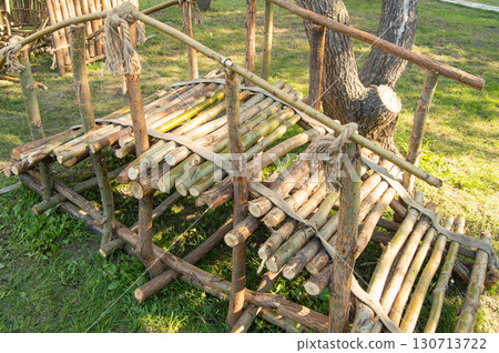 Rustic log structure with jute rope on grass 130713722