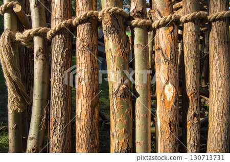 Vertical logs with bark and jute rope natural wood texture 130713731