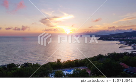 Sunset over the sea coast, golden reflection on water and panoramic horizon 130713841