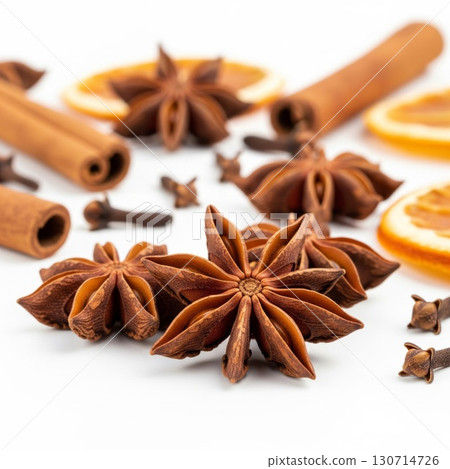 Aromatic Spices Still Life with Cinnamon Sticks Star Anise and Orange Slices on White Backdrop 130714726