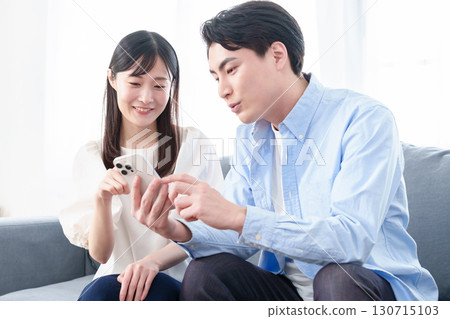 Young men and women using smartphones Young men and women using smartphones 130715103