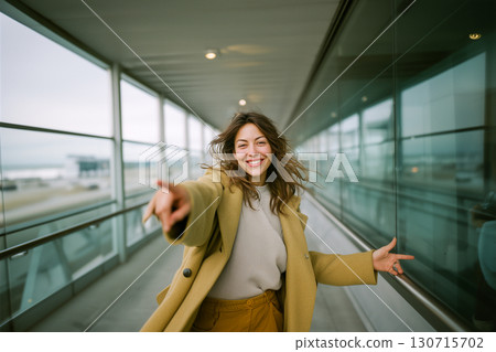 A woman in a yellow coat is smiling and pointing to the sky A woman in a yellow coat is smiling and pointing to the sky 130715702