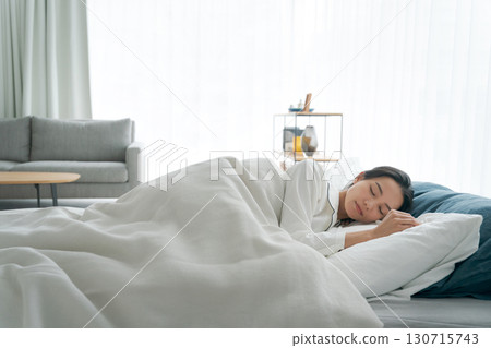 A young woman sleeping in bed 130715743